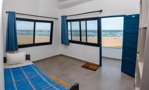 蓬塔杜欧鲁Ponta Mar Resort的一间带床的卧室，可欣赏海滩景色