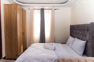 1 dormitorio con 1 cama grande y ventana grande en SpringStone Studio Apartment Rm 19 en Langata Rongai
