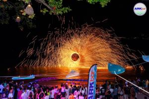 een menigte mensen op een vuurwerk evenement 's nachts bij Arkbar Beach Club in Chaweng Beach