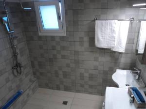 Un baño con ducha, inodoro y ventana. en The Getaway, en Agia Marina de Nea Kydonia 20 fotos más