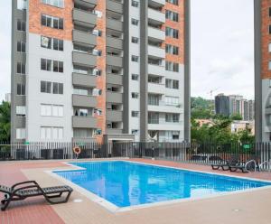 a swimming pool in front of a tall building at Sabaneta 22 in Sabaneta