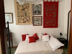 um quarto com uma cama com almofadas vermelhas e brancas em Cal Bonic em Riudarenes