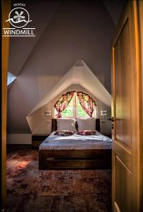 a bedroom with a large bed with a window at Windmill Resort Agroturystyka in Mucharz