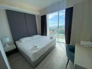 a bedroom with a white bed and a large window at Nilam Residence ARU SUITES Sea View 2BR INFINITY POOL in Kota Kinabalu