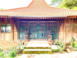 a building with a green door with statues on it at Villa Kepuh in Singaraja