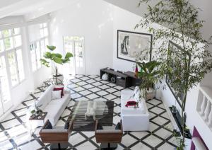 un salon avec des meubles blancs et des plantes en pot dans l'établissement Prestige Property - Da Costa, à Rio de Janeiro