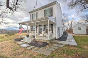 a white house with an american flag on the porch at Sunny Front Royal Vacation Rental with Hot Tub! in Front Royal