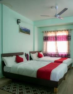 due letti in una camera da letto con finestra di Hotel Elite Pokhara a Pokhara