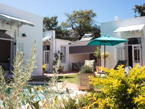une maison avec un jardin et un parasol dans l'établissement Kolonie's Tuin, à Stellenbosch