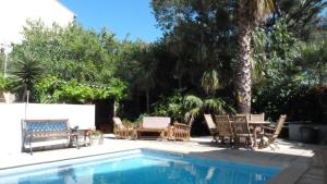 einen Pool mit Stühlen, einem Tisch und Stühlen in der Unterkunft Maison jardin grande piscine , sortie bateau possible in Marseille