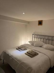 um quarto com uma cama branca e toalhas em Appartement rénové em Savièse