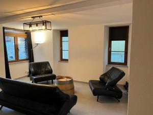 uma sala de estar com duas cadeiras e uma mesa em Appartement rénové em Savièse