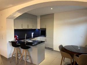 a kitchen with a counter and a sink and a table at Appartement rénové in Savièse