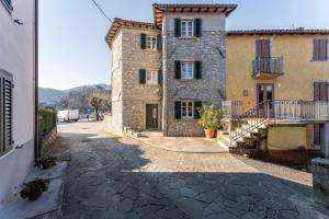 una antigua casa de piedra con una calle adoquinada en Limoni, en Molazzana