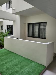 uma casa branca com um relvado verde em frente em Elegant 1-bedroom apartment with close amenities em Quatre Bornes
