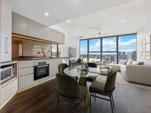 cocina y sala de estar con mesa y sillas en Stylish Stay for Couples in CBD by Stylish Stays en Brisbane