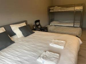 een slaapkamer met een groot wit bed en 2 stapelbedden bij Appelscha aan de diek in Appelscha