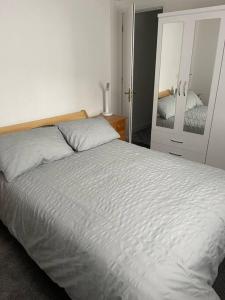 um quarto com uma cama branca e um espelho em Quirky one bed flat, Barbican area, Plymouth em Plymouth