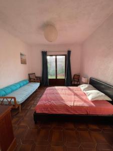 ein Schlafzimmer mit einem großen Bett und einem Fenster in der Unterkunft Villa Maxime in Porto-Vecchio