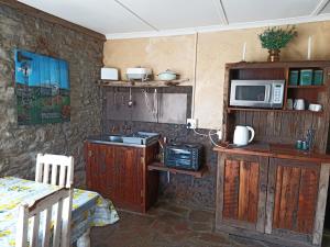 a kitchen with wooden cabinets and a microwave at Die Stal in Sutherland