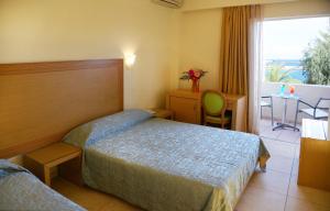a hotel room with two beds and a table at Itanos in Sitia
