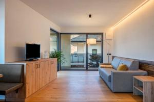 a living room with a couch and a tv at Falsers Mountain Lodge in Cornedo all'Isarco