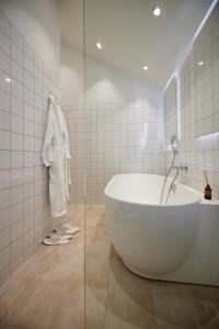 y baño con bañera grande y ducha. en Borre Knob konferencecenter, en Juelsminde