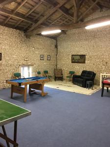 a room with a ping pong table and chairs at Logis de L'Arceau in Celles