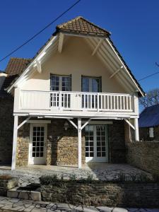 a white house with a balcony on top at L'ABRIGIT in Curcy-sur-Orne