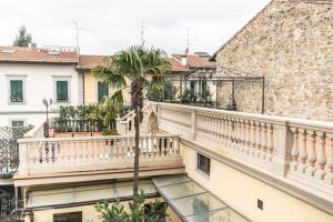 uma varanda com uma palmeira em frente a um edifício em Cozy Suite By Villa Il Mosaico em Florença