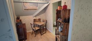 a small room with a small table and a stairway at L'ABRIGIT in Curcy-sur-Orne