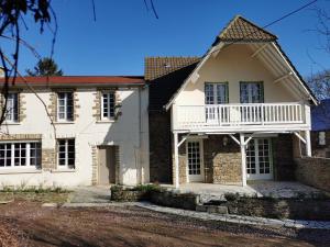 Biały dom z werandą i balkonem w obiekcie L'ABRIGIT w mieście Curcy-sur-Orne
