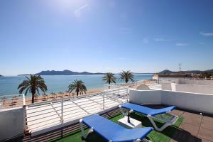a balcony with two blue chairs and a view of the beach at Apartment Sivella in Pollença