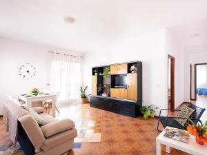 ein Wohnzimmer mit einem Sofa und einem TV in der Unterkunft Limoncello Home con Veranda vista Mare a 3 Min dalla spiaggia in Alcamo