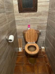 a bathroom with a wooden toilet in a stall at Villa Maxime in Porto-Vecchio