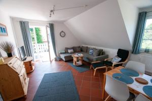 uma sala de estar com um sofá e uma mesa em FeWo Hartmann em Strukkamp auf Fehmarn