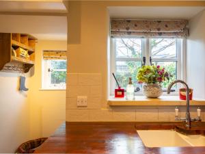 a kitchen with a sink and a window at Thimble Cottage in Lower Slaughter