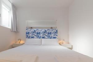 ein weißes Schlafzimmer mit einem großen Bett mit blauen und weißen Tapeten in der Unterkunft I Host Apartment - Val Strona (2) in Mailand