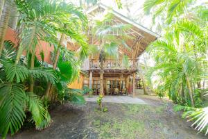 a wooden house with palm trees in front of it at Ziwa Beach Resort in Bamburi