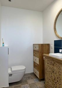 een badkamer met een toilet, een wastafel en een spiegel bij Haut de villa avec jacuzzi et extérieur in Lançon-Provence