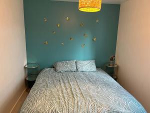 een slaapkamer met een bed en een blauwe muur bij Haut de villa avec jacuzzi et extérieur in Lançon-Provence