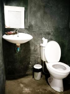 a bathroom with a white toilet and a sink at Leam Sai Bungalows Koh Yao Noi in Ko Yao Noi