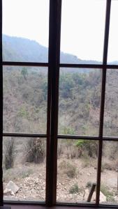 a view from a window of a mountain at Hedony Farmhouse with 2 Bedrooms and Swimming pool in Rishīkesh
