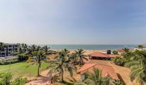 z góry widok na ośrodek z palmami i ocean w obiekcie Hotel Ocean Face, BAGA w mieście Baga