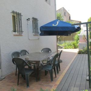 stół, krzesła i parasol na patio w obiekcie appartement 3 chambres w mieście Bompas