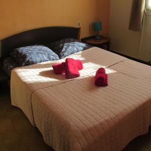 Una cama con dos toallas rojas encima. en appartement 3 chambres, en Bompas