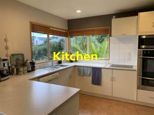 a kitchen with a kitchen sign on the window at Homestay, millions dollars view at Mount Pleasant in Christchurch