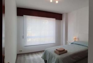 1 dormitorio con cama y ventana grande en Vistas a la ría de Muros Noia en Portosín, en Portosín