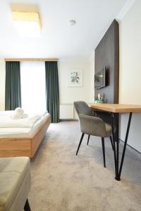 a hotel room with a desk and a bed at Pension Ebnerwirt in Eben im Pongau