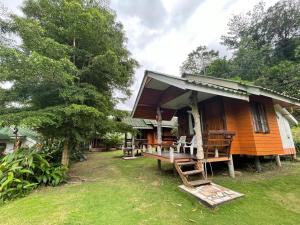 una casa con un banco delante de ella en Mangrove bungalow & restaurant, en Ko Kood